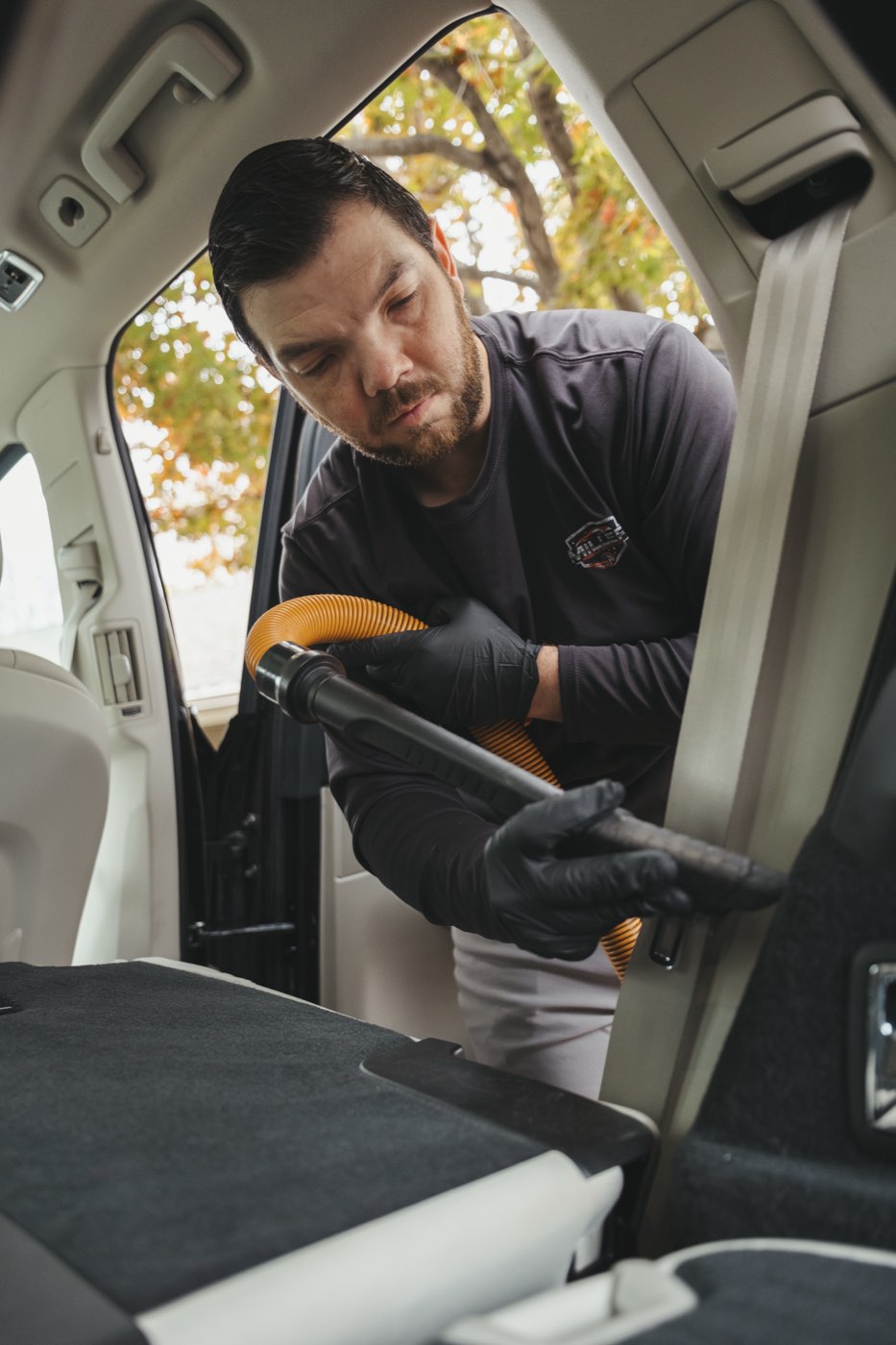 Vacuuming the cargo area of an SUV, where pet hair collects, during an interior detail